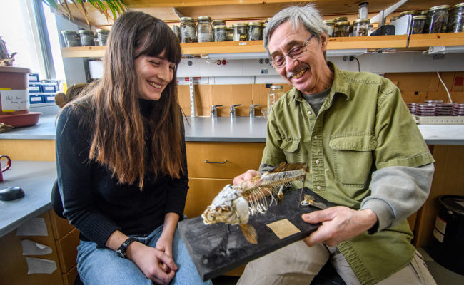 Professor John Baker with female student showing rock