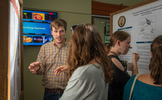 professor looking over poster with stud