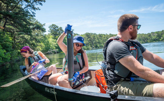 students in canoe and taking samples