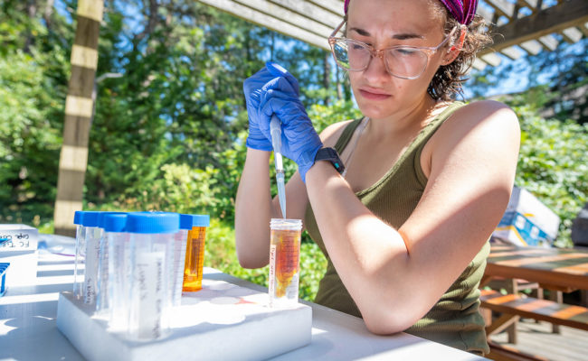 female student taking water sample