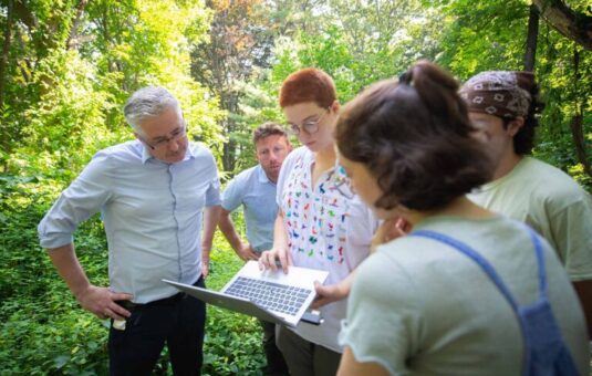 students with professor in forest