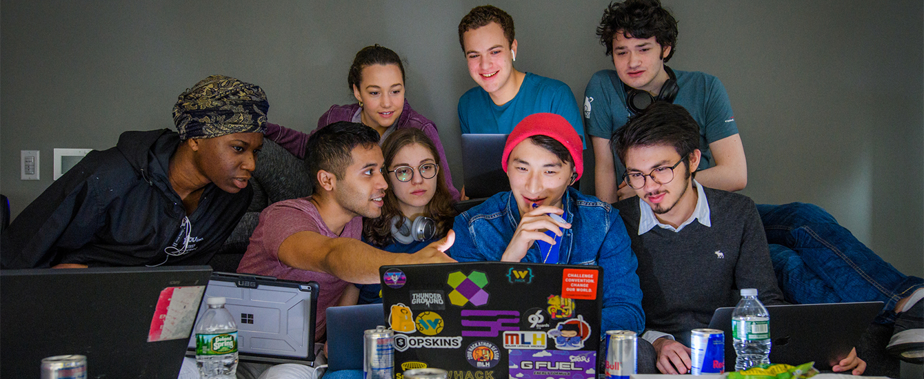 a dozen kids looking over a computer
