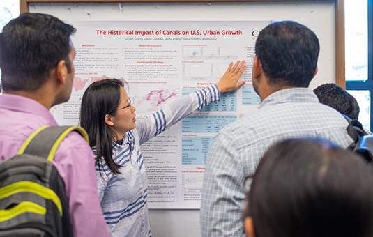 Economics student showing poster at exhibi