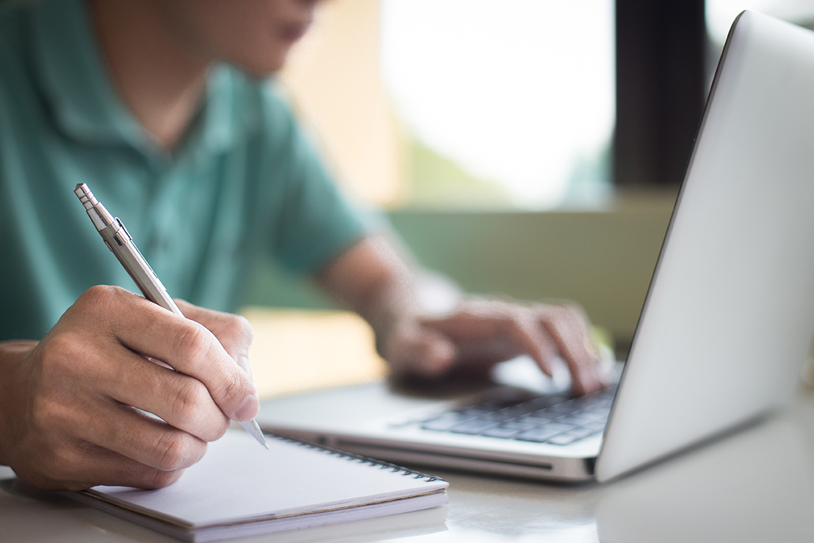 student typing in laptop